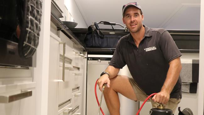 Kye Chapple sprays the skirting boards in this home to defend against pesky cockroaches, which are thriving in the warm and wet weather. PICTURE: GIZELLE GHIDELLA.