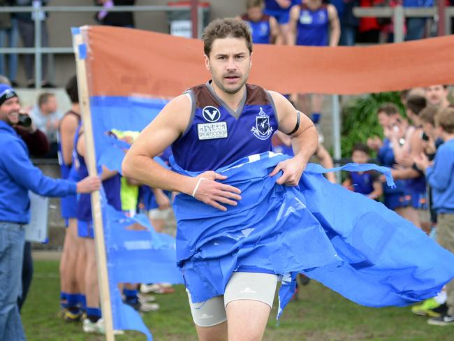 s08fs833   Peninsula forward Shaun Payze runs through a banner for his 300th game.