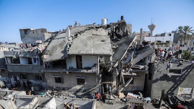 People search through buildings, destroyed during Israeli raids. Picture: Ahmad Hasaballah