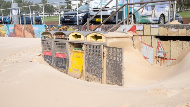 Rubbish bins covered in sand on the beachfront. Picture Thomas Lisson