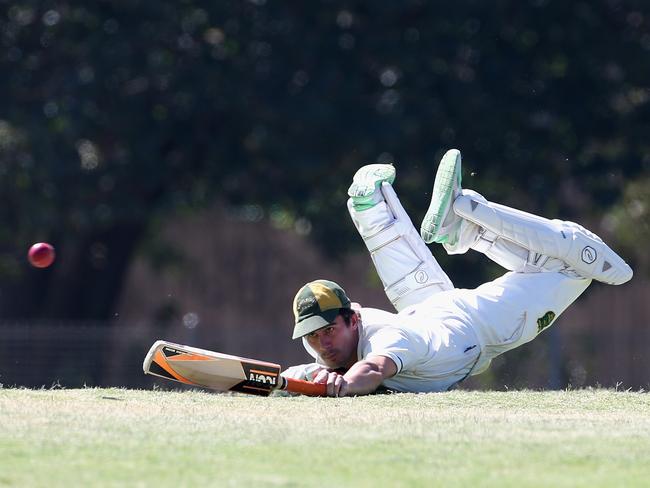 Bill Biggs dives to make his ground while batting for Bentleigh ANA.