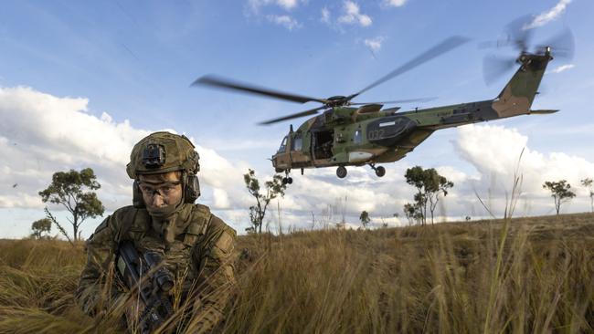 Soldiers from the 4th Regiment, Royal Australian Artillery and 3rd Battalion, The Royal Australian Regiment dismount from an MRH-90 Taipan during Exercise Chau Pha in Townsville Field Training Area, Queensland.