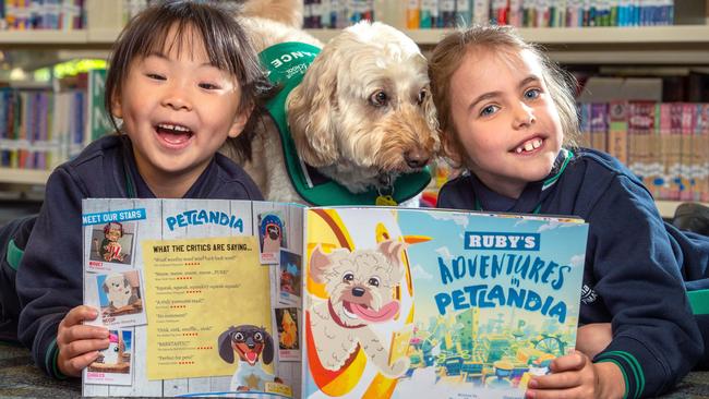 Grade 1 students Yolanda, 6, and Chloe, 7, read a book about Ruby the labradoodle, written by Grade 3 students at Orchard Grove Primary. Picture: Jay Town