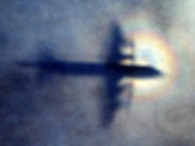 FILE - In this March 31, 2014 file photo, the shadow of a Royal New Zealand Air Force P3 Orion is seen on low level cloud while the aircraft searches for missing Malaysia Airlines Flight MH370 in the southern Indian Ocean, near the coast of Western Australia. The director of a seabed hunt for Malaysia Airlines Flight 370 on Tuesday, May 22, 2018, disagreed with a new book's conclusion that the pilot likely flew the plane beyond the search area to deliberately sink it in unexplored depths of the Indian Ocean.(AP Photo/Rob Griffith, File)