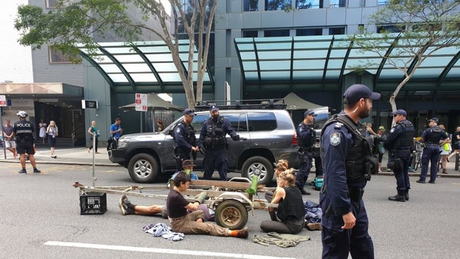 Protesters with their arms attached to a trailer block George St in the city. Picture: Cloe Read