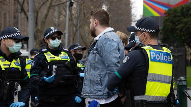 A large police presence as people gather for a protest to rally for freedom of speech, movement, choice, assembly, and Health in Melbourne. A man is handcuffed by police. Picture: NCA NewsWire/Sarah Matray