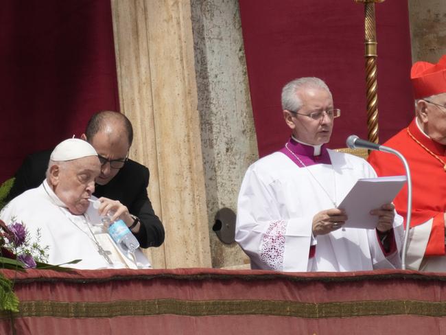 Pope Francis, left, sips water as he appears at the central lodge of St. Peter's Basilica to bestow the Urbi et Orbi blessing at the end of the Easter mass presided over by Cardinal Angelo Comastri. Picture: AP