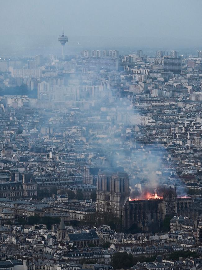 Smoke and flames rise during a fire at the landmark Notre-Dame Cathedral in central Paris on April 15, 2019, potentially involving renovation works being carried out at the site, the fire service said. - A major fire broke out at the landmark Notre-Dame Cathedral in central Paris sending flames and huge clouds of grey smoke billowing into the sky, the fire service said. The flames and smoke plumed from the spire and roof of the gothic cathedral, visited by millions of people a year, where renovations are currently underway. (Photo by Philippe LOPEZ / AFP)