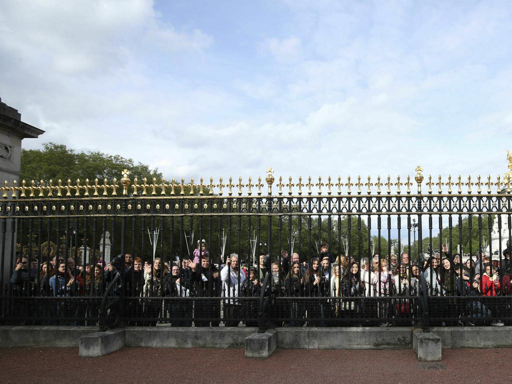 Crowds gather outside Buckingham Palace to take pictures of the historic announcement. Picture: Yui Mok/Pool Photo via AP