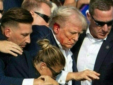 Republican candidate Donald Trump is seen with blood on his face surrounded by secret service agents as he is taken off the stage at a campaign event in Butler, Pennsylvania, July 13, 2024. Picture: AFP