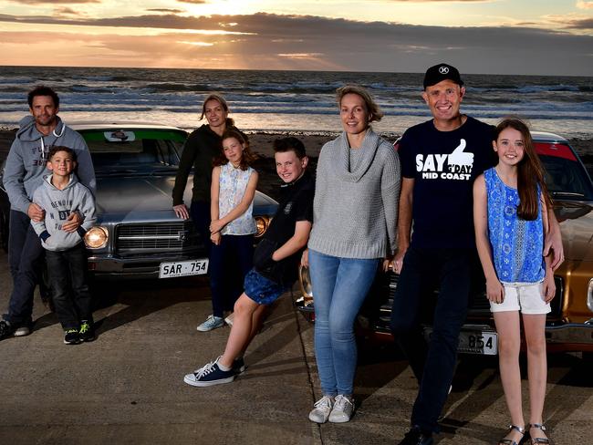 Dan, Nathan, Joanne and Zoe Flesfadar with Ben, Lucie, Mark and Abby Dittmar and their Holden HQ Premier 1974 (silver) and Holden HQ Kingswood 1974 (gold) on Moana Beach. Picture: BIANCA DE MARCHI