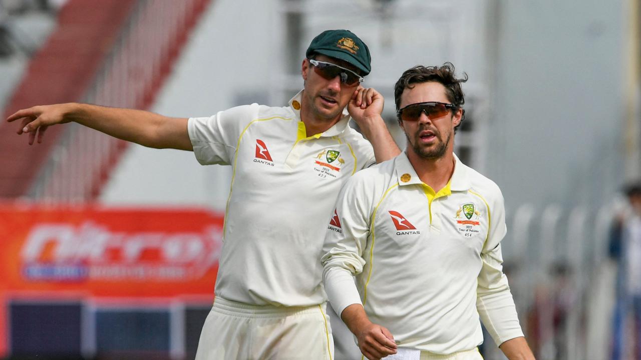 Australia's captain Pat Cummins (L) speaks with bowler Travis Head during the fifth day of the first Test cricket match between Pakistan and Australia at the Rawalpindi Cricket Stadium in Rawalpindi on March 8, 2022. (Photo by Aamir QURESHI / AFP)