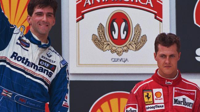 Damon Hill of Great Britain, driver of the #5 Rothmans Williams Renault Williams FW18 Renault RS8 V10 celebrates over Michael Schumacher after winning the Brazilian Grand Prix on 31st March 1996 at the Autodromo Jose Carlos Pace, Interlagos, Brazil. (Photo by Ben Radford/Getty Images)