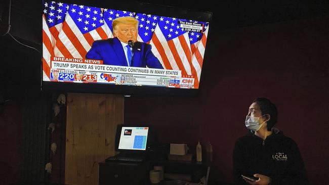 A waitress watches the US Election while at work at a cafe in Beijing, China. Picture: Getty Images