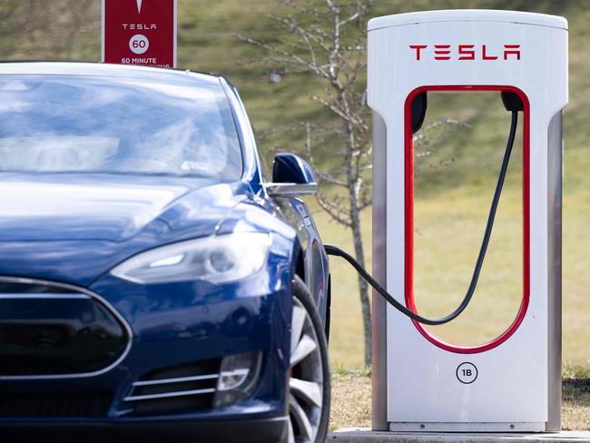 (FILES) A Tesla Model S sedan is plugged into a Tesla Supercharger electrical vehicle charging station in Falls Church, Virginia, February 13, 2023. Tesla will open its network of superchargers in the United States and Canada to Ford electric vehicles from 2024, the companies said Thursday, doubling the stations available to Ford customers. (Photo by SAUL LOEB / AFP)