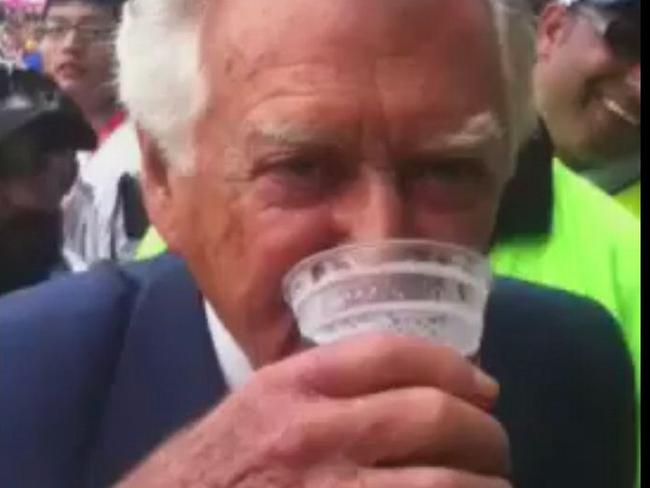 Former Prime Minister Bob Hawke skolling a beer.