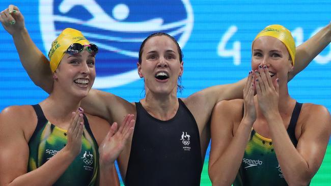 Emma McKeon, Brittany Elmslie and Bronte Campbell of Australia celebrate after Cate Campbell touches the wall to give Australia gold.