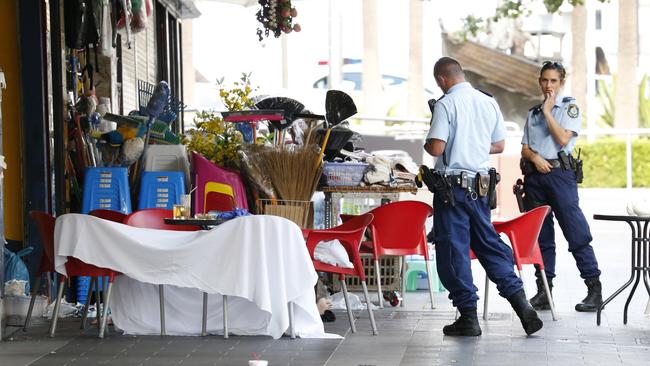 The body of Ho Ledinh lies behind a white sheet as police search the scene. Picture: David Swift