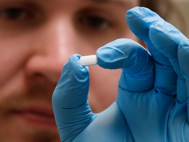 A pharmacy technician holds a hydroxychloroquine tablet. Picture: George Frey/AFP