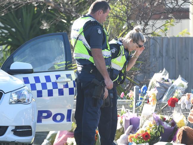 Local police stop to view the flowers toys and messages left at the home. Picture: Lawrence Pinder