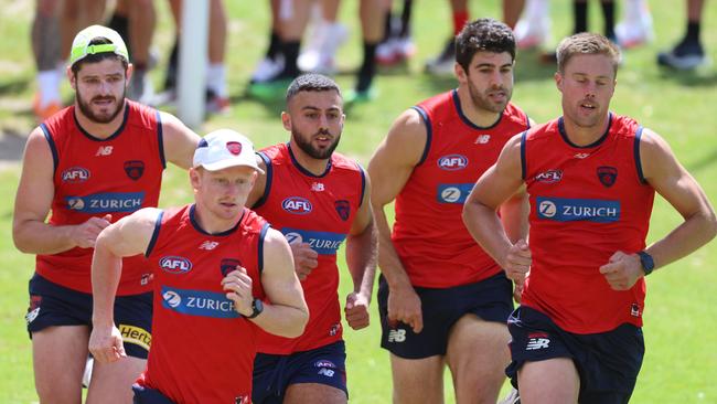 Demons Angus Brayshaw, Jake Bowey, Christian Salem, Christian Petracca and Josh Schache take part in a high intensity running drill at Lorne’s Stribling Reserve on Wednesday. Picture: Brendan Beckett