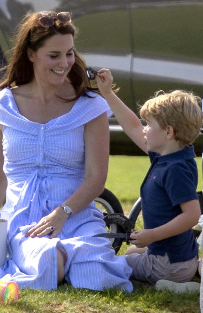 Britain's Kate, the Duchess of Cambridge , left smiles at Prince George plays with a toy knife. Picture: AP