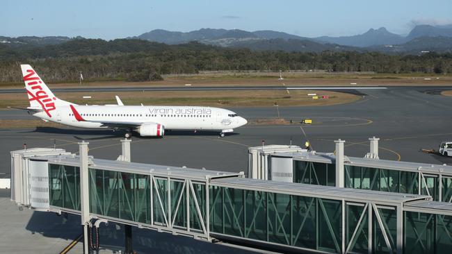 A Virgin Australia flight passes aerobridges at Gold Coast airport. Picture: Glenn Hampson.