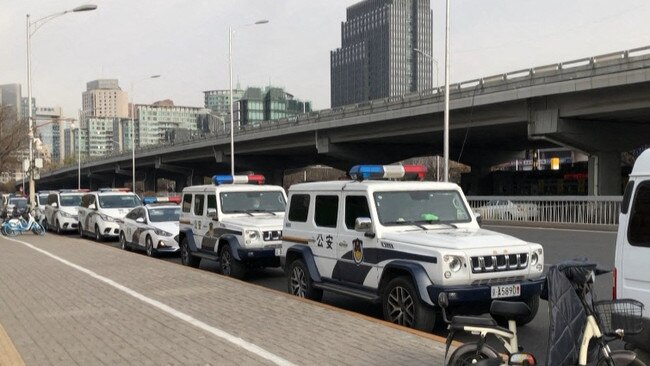 Police cars and vans parked along a street in Beijing on Monday, after protesters gathered in various cities over the weekend. Picture: AFP