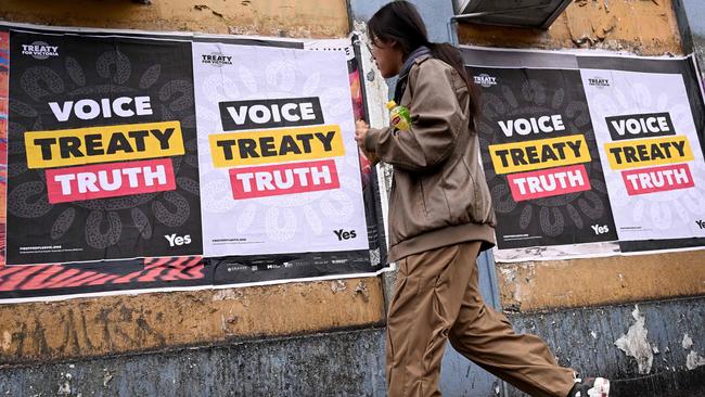 A woman walks past posters advocating for an Aboriginal voice and treaty ahead of the October 14 referendum. Picture: AFP