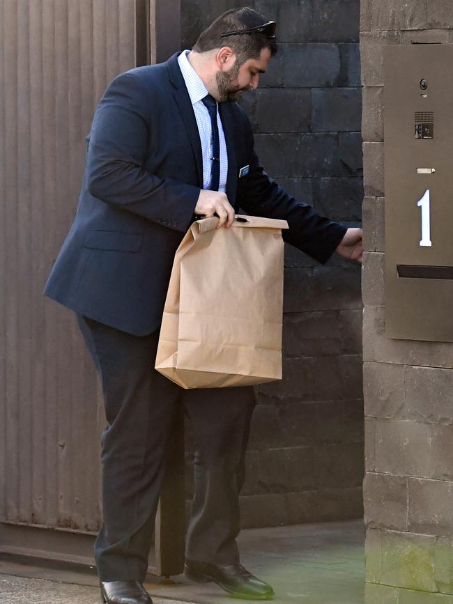 NSW Police detectives hold an evidence bag as they leave John Ibrahim’s mansion. Picture: AAP