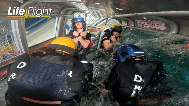 Dr Fergus Hannon (left) is plunged underwater during a simulated helicopter crash. Photo: LifeFlight.