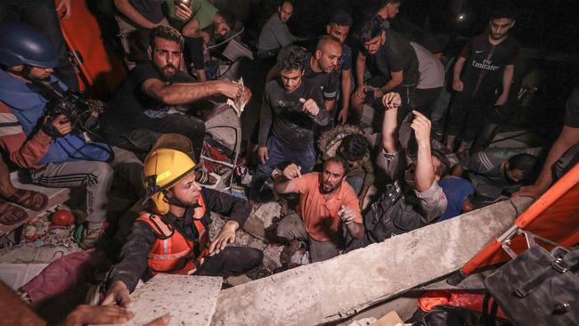 Palestinian firefighters search for survivors after an intensive civilian bombardment of Gaza City on Sunday. Picture: AFP