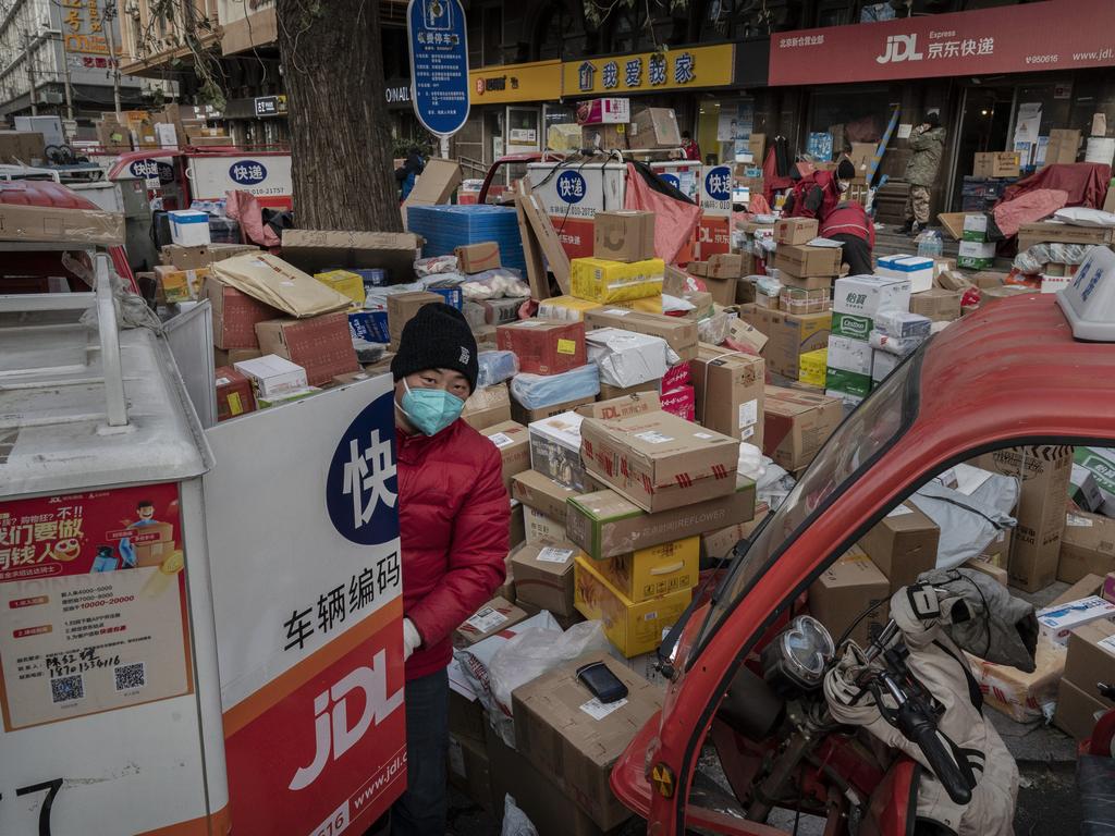 A Beijing delivery driver organises packages that are part of a backlog due to Covid-19 outbreaks. Picture: Kevin Frayer/Getty Images