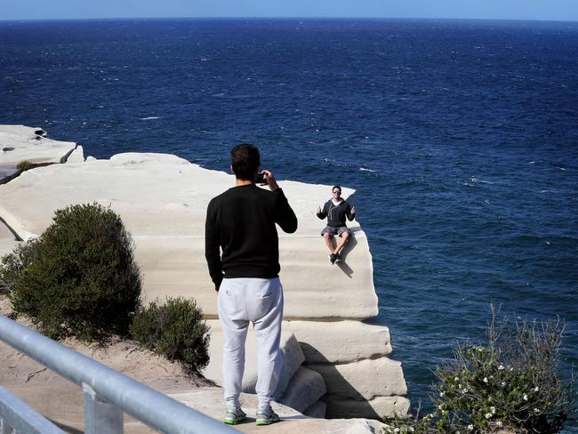 Walkers take pictures near the cliffs edge at Wedding Cake Rock. Picture: John Feder/The Australian.