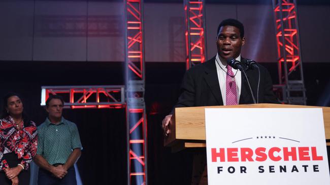 Georgia Republican Senate candidate Herschel Walker delivers his concession speech as his wife Julie Blanchard and former football player Doug Flutie look on in Atlanta, Georgia. Picture: AFP