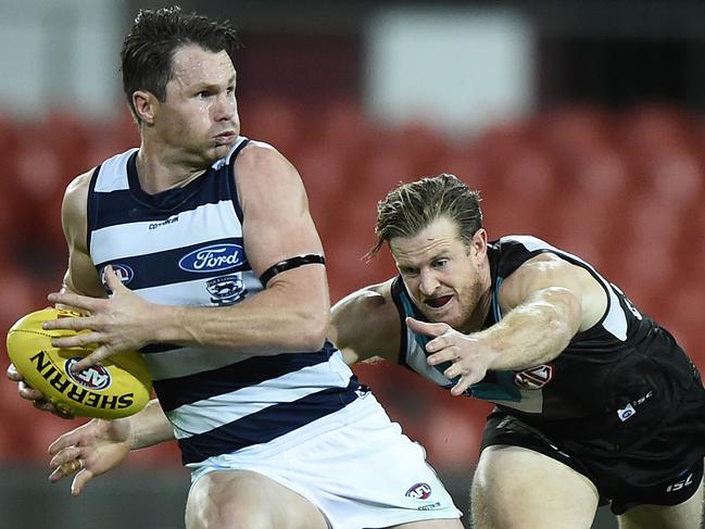 GOLD COAST, AUSTRALIA - AUGUST 14: Patrick Dangerfield of the Cats breaks free of a tackle during the round 12 AFL match between the Geelong Cats and the Port Adelaide Power at Metricon Stadium on August 14, 2020 in Gold Coast, Australia. (Photo by Matt Roberts/Getty Images)