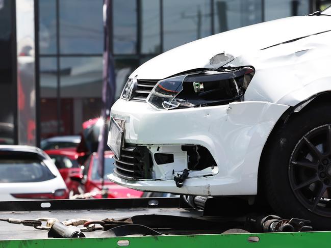 Emergency services personnel attend the scene of a traffic crash between a small car and a scooter at the intersection of Mulgrave Road and Newell Street, Bungalow. The car involved in the crash is towed away from the scene. Picture: Brendan Radke