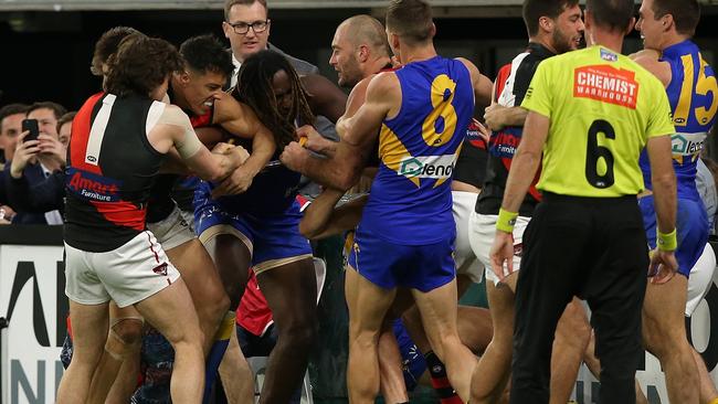 Essendon players wrestle with Nic Naitanui after the Eagles star pushed Zach Merrett into the fence. Picture: Getty Images