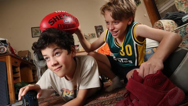 Arleigh plays video games while mate Luke tries to entice him to get active. Picture: Alex Coppel