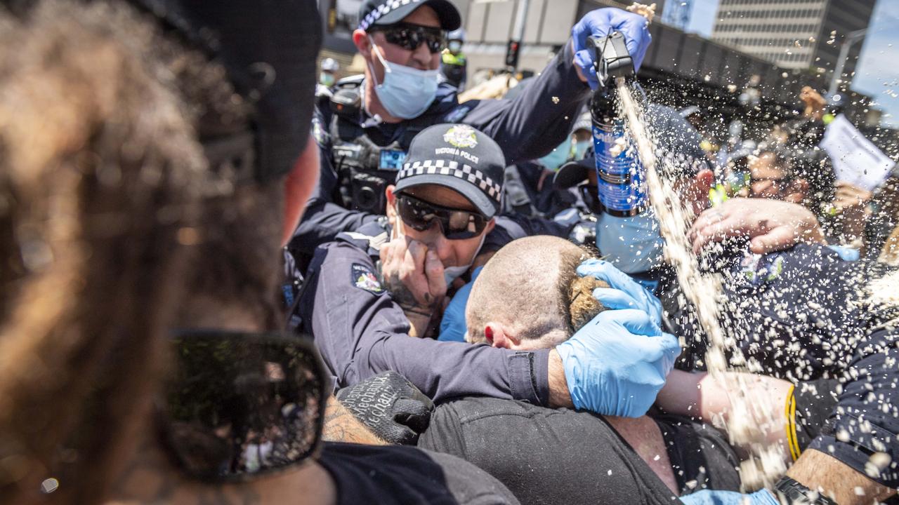 A protester is arrested as police use pepper spray during the Melbourne Cup Day rally. Picture: Jake Nowakowski