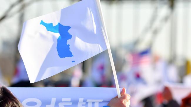 A supporter of the unified Korea female ice hockey team waving a "Unification flag". Picture: AFP.