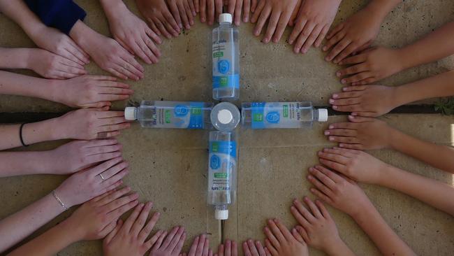 HELPING HANDS. The students of Empire Vale Public School are grateful for their gift of hand and surface sanitiser from the Sunshine Sugar Mill. Photo: Karen Rantissi