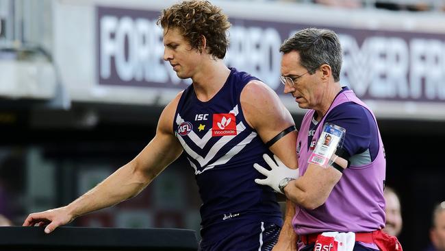 PERTH, AUSTRALIA - APRIL 07: Nat Fyfe of the Dockers is assisted off the field after sustaining a head knock the 2019 AFL round 03 match between the Fremantle Dockers and the St Kilda Saints at Optus Stadium on April 07, 2019 in Perth, Australia. (Photo by Will Russell/AFL Media/Getty Images)
