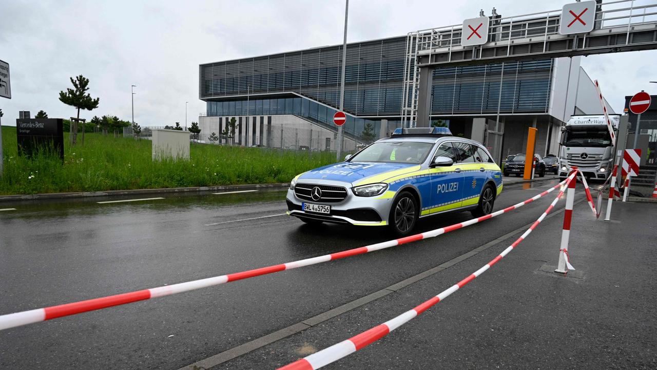 A police car departs from the factory grounds.  (Photo credit: THOMAS KIENZLE/AFP)