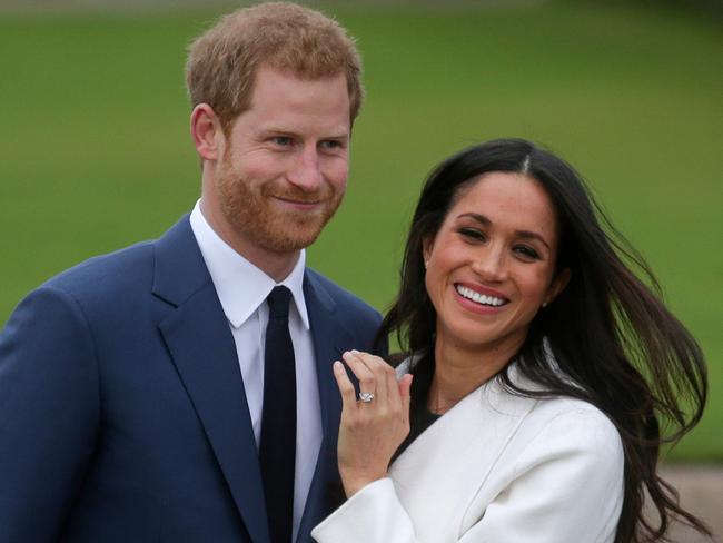 (FILES) In this file photo Britain's Prince Harry stands with his fiancée US actress Meghan Markle as she shows off her engagement ring whilst they pose for a photograph in the Sunken Garden at Kensington Palace in west London on November 27, 2017, following the announcement of their engagement. - Queen Elizabeth II and other senior British royals were gathering for a meeting Monday with Prince Harry in an attempt to solve the crisis triggered by his bombshell announcement that he and wife Meghan were stepping back from the royal frontline. Harry's father Prince Charles and brother Prince William, with whom he has strained relations, will join the monarch at her private Sandringham estate in eastern England, according to British media. (Photo by Daniel LEAL-OLIVAS / AFP)