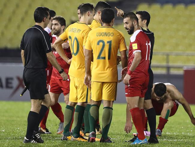 Australian players talk to referee Alireza Faghani about a controversial penalty