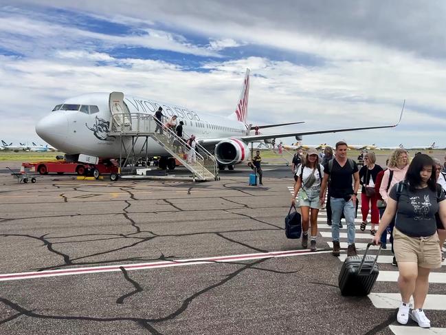 Tourist and passengers arrive at Alice Springs airport off a Virgin Australia flight.