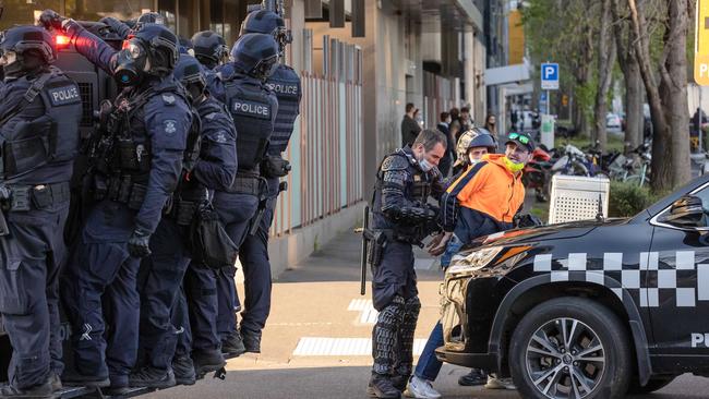 Riot police arrest a man during anti-lockdown protests in Melbourne. Picture: Jason Edwards