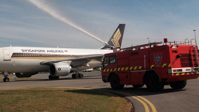 A Singapore Airlines welcomed by a fire truck at Adelaide Airport … there are concerns over moves to cut rescue and firefighting personnel.