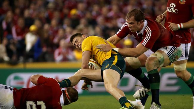 James O’Connor is wrapped up by the British &amp; Irish Lions defence at Etihad Stadium in 2013. Picture: Colleen Petch